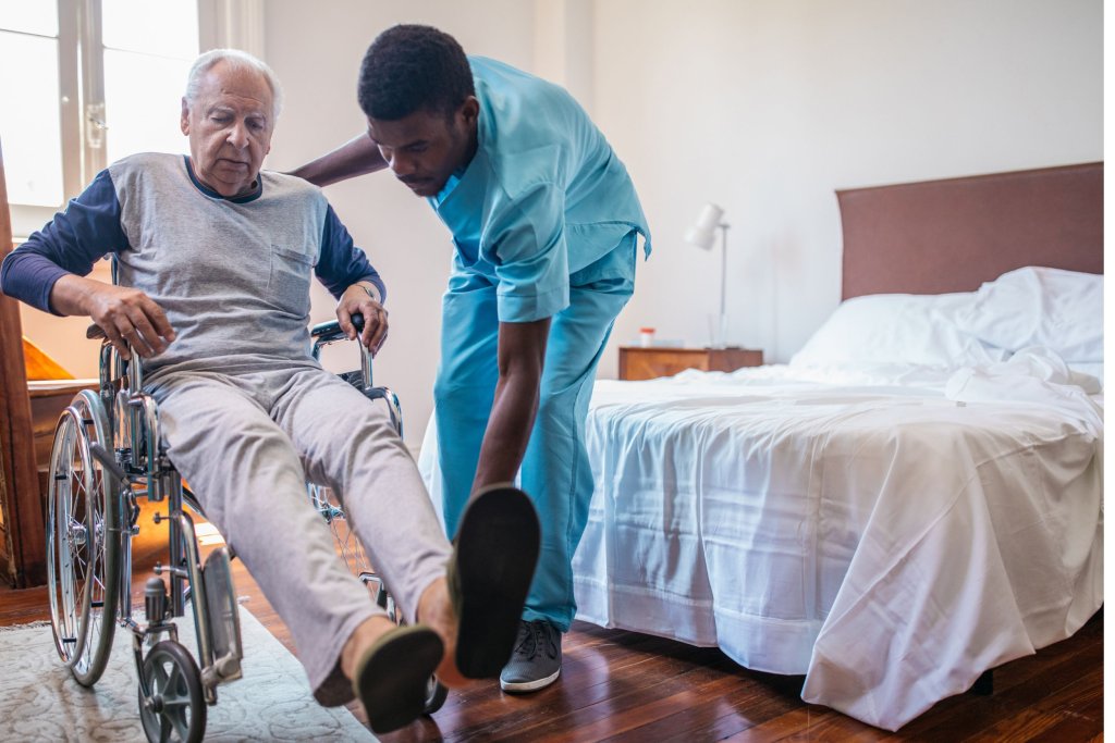 A male nurse helping a patient in a wheelchair