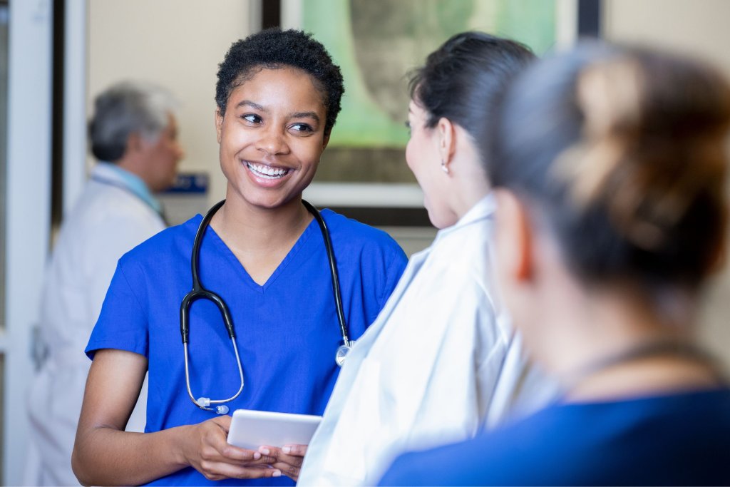 A young travel nurse smiling at a doctor