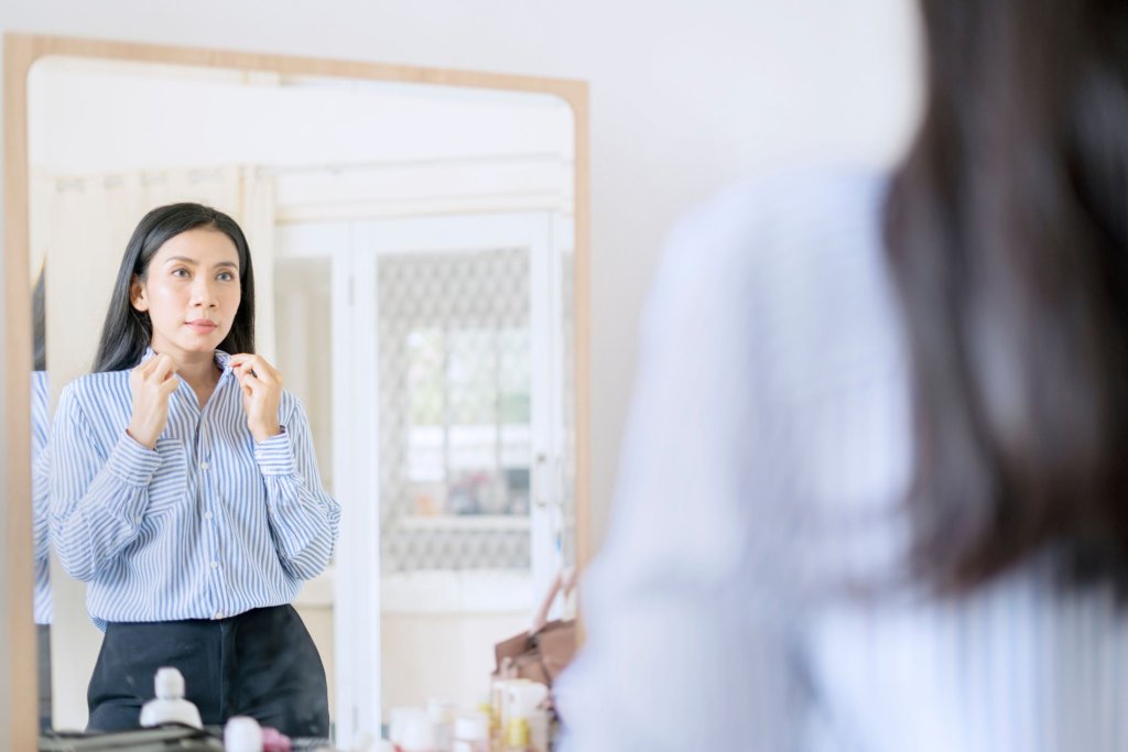 A woman looking in the mirror as she gets ready for a job interview