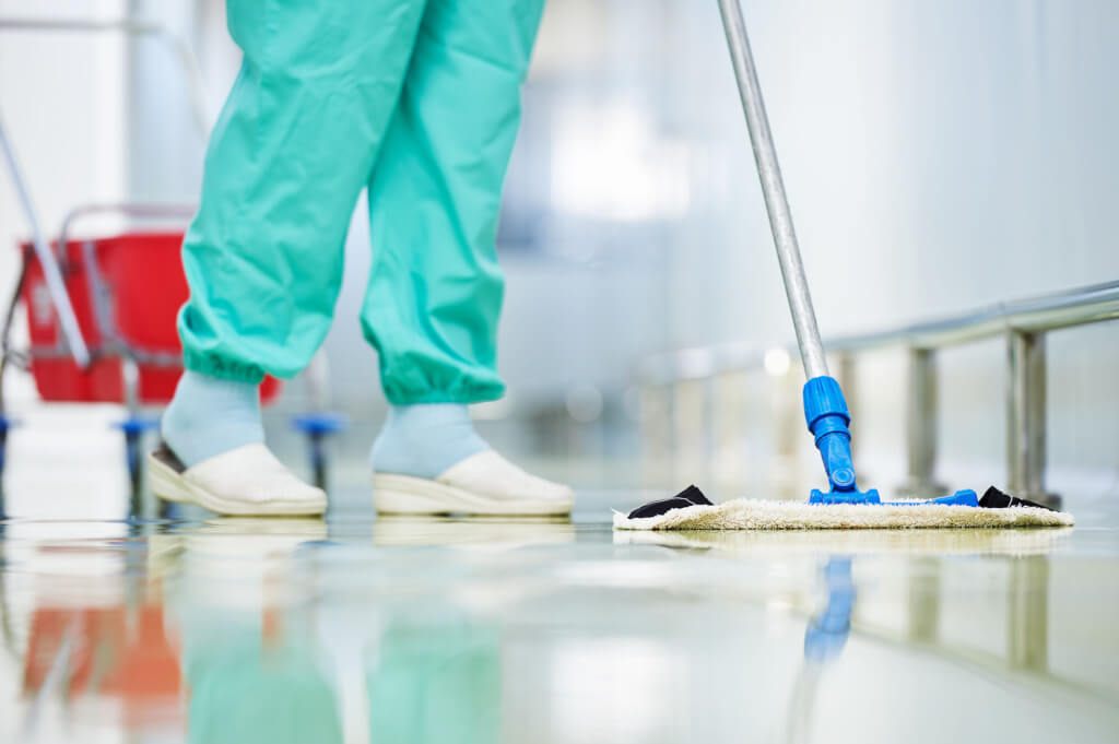 Someone in scrubs mopping a hospital floor - one of the ways to promote patient safety.